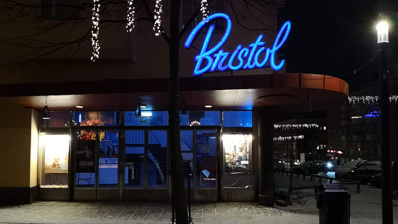 Snöig gata med biografen Bristol i Sundbyberg i nattbelysning