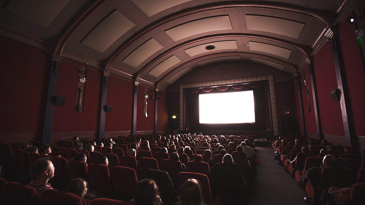 En bild som visar en biografsalong med publik.